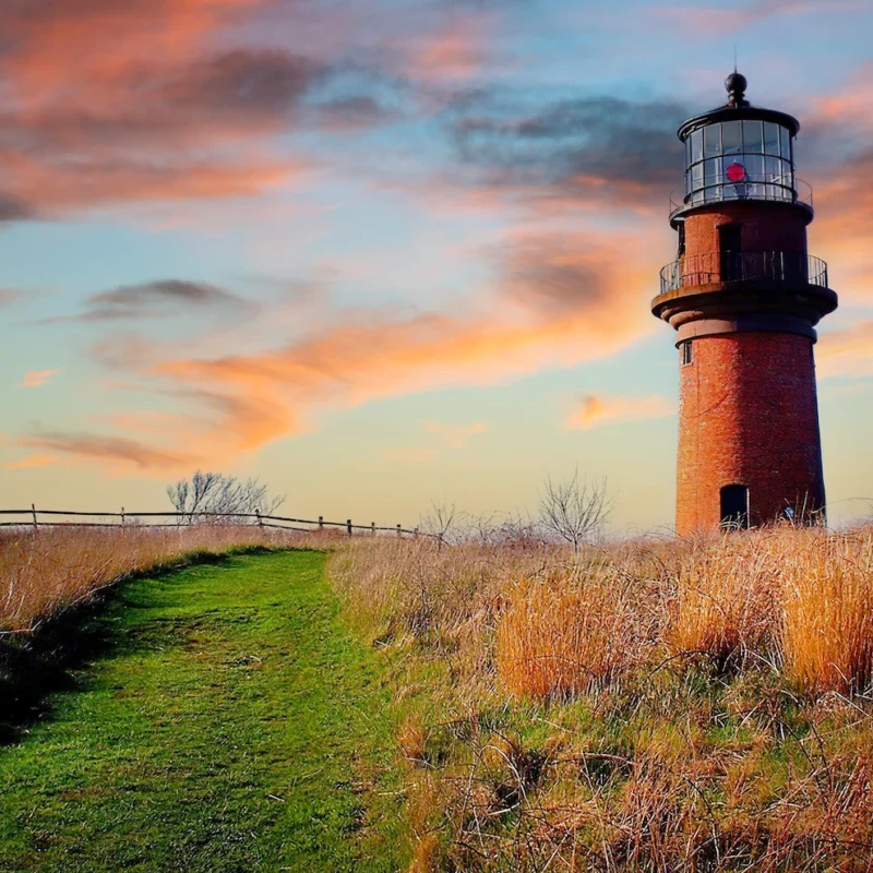 lighthouse on grassy beach hill
