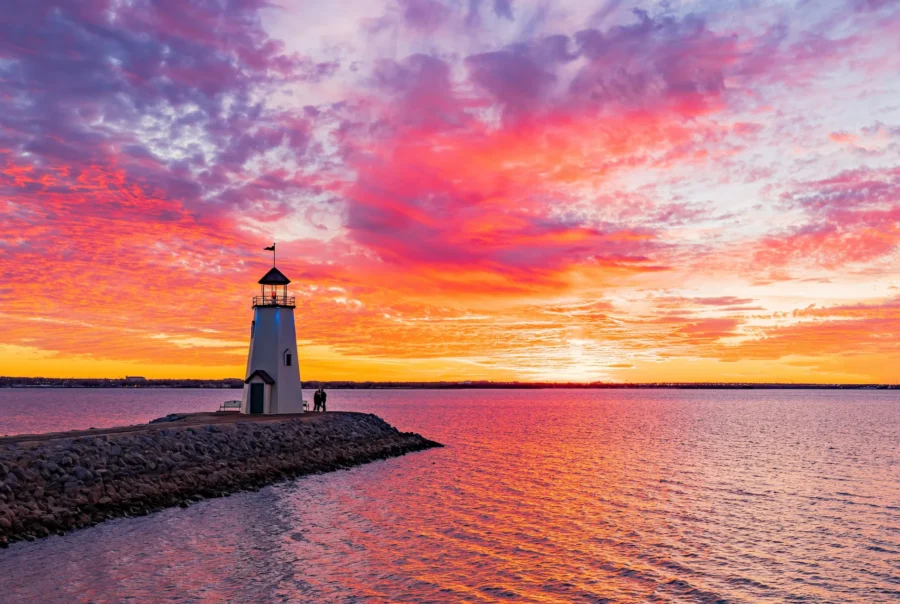 beautiful scene of a lighthouse looking over the ocean at sunrise